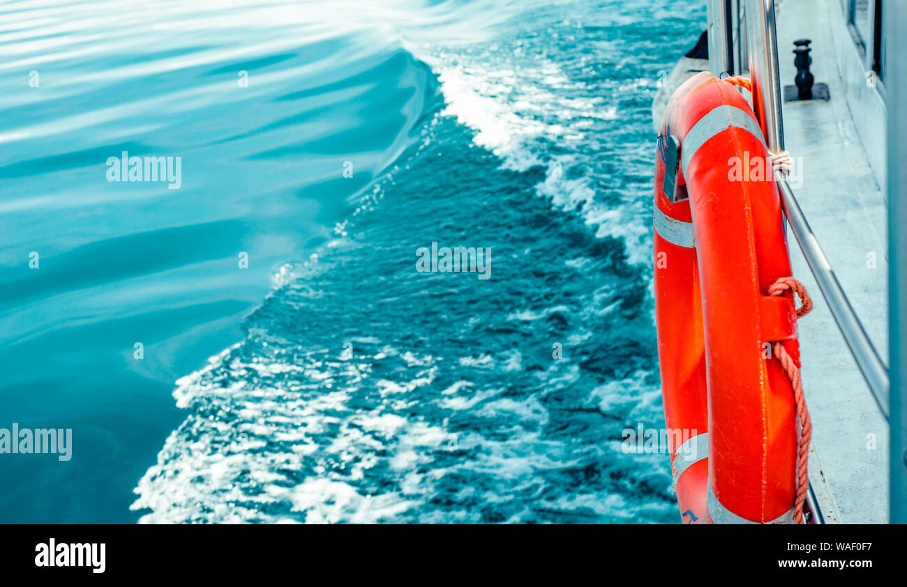Bouée rouge sur la surface de la mer avec garde-corps de navire. Banque D'Images