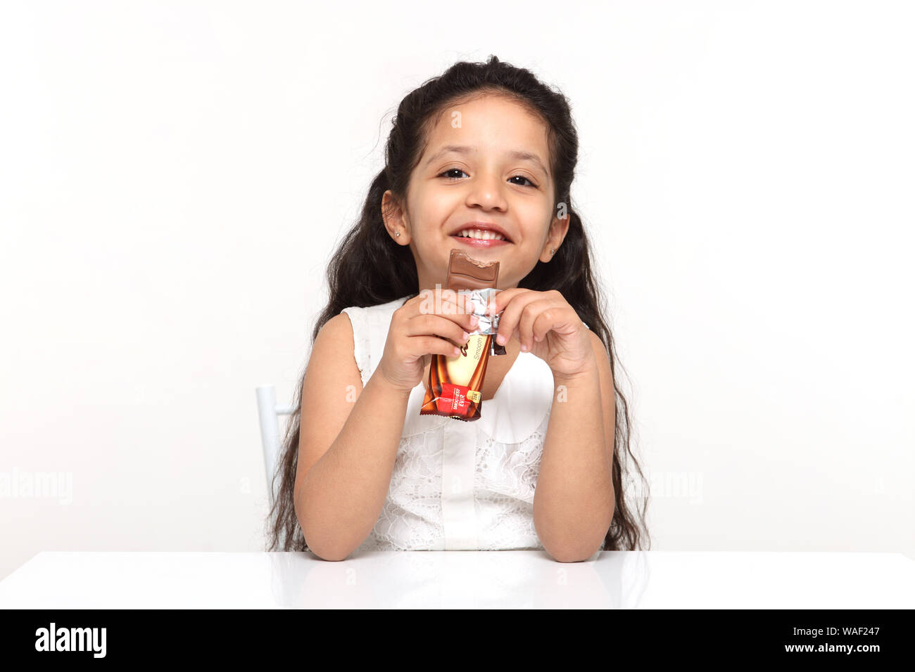 Girl eating a chocolate bar Banque D'Images