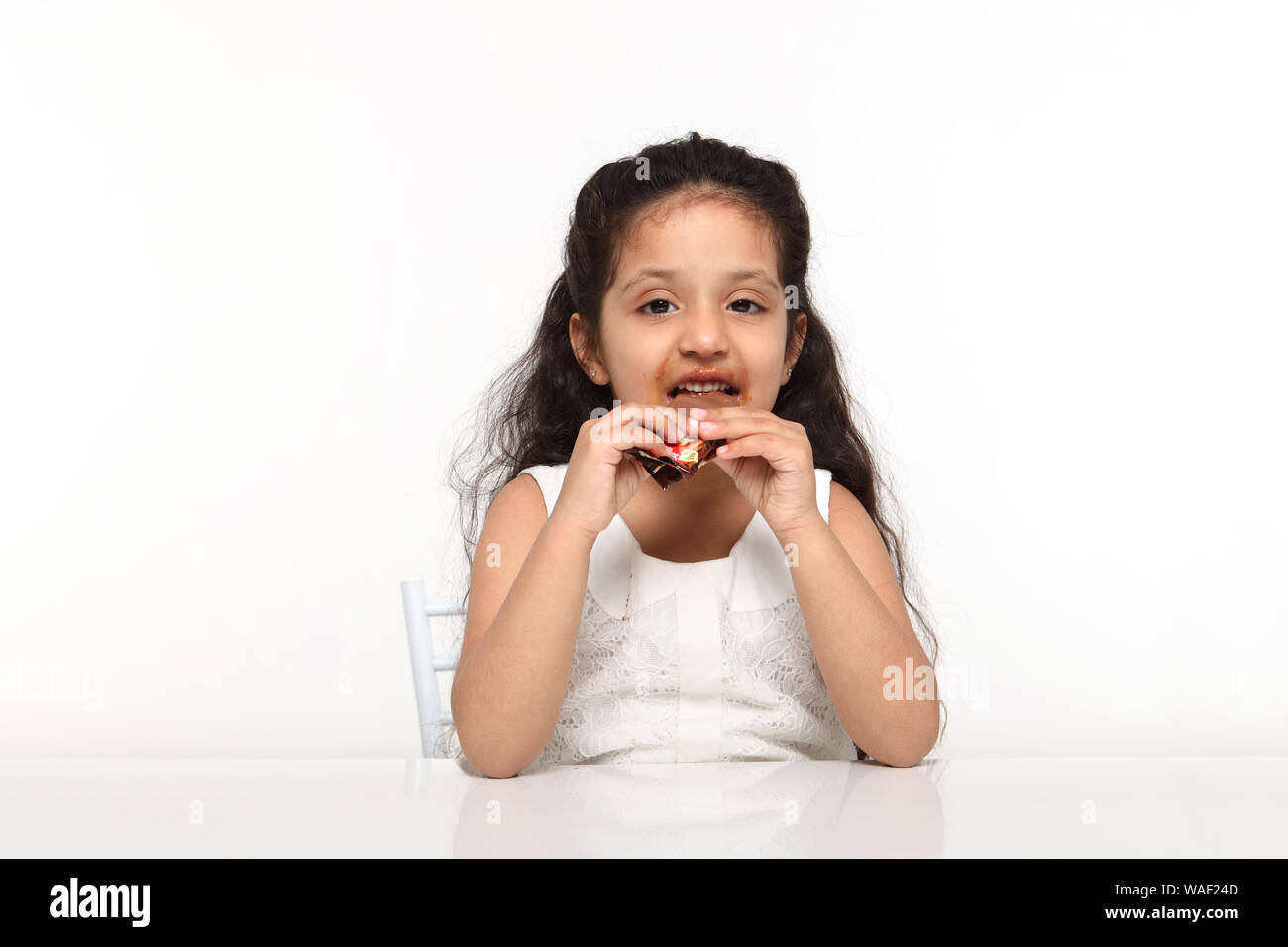 Girl eating a chocolate bar Banque D'Images