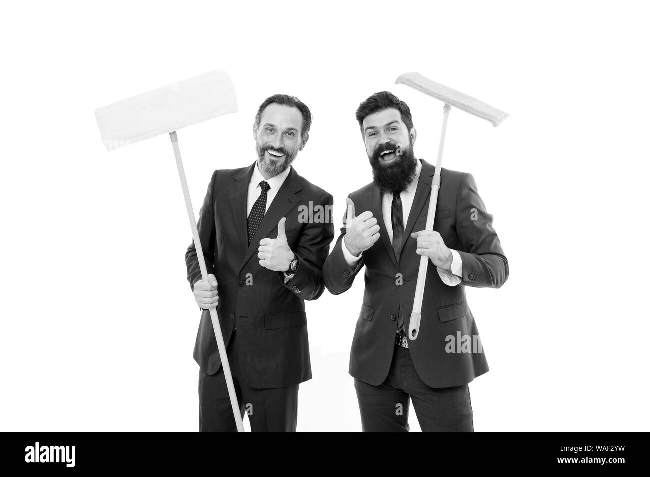 Hommes d'effacer à mur blanc. ardoise propre. entreprise de nettoyage. nettoyer les barbus mature. d'affaires en costume officiel householding hold mop. Le partenariat et le travail en équipe. Sentir le parfum. Nous l'avons fait. Banque D'Images