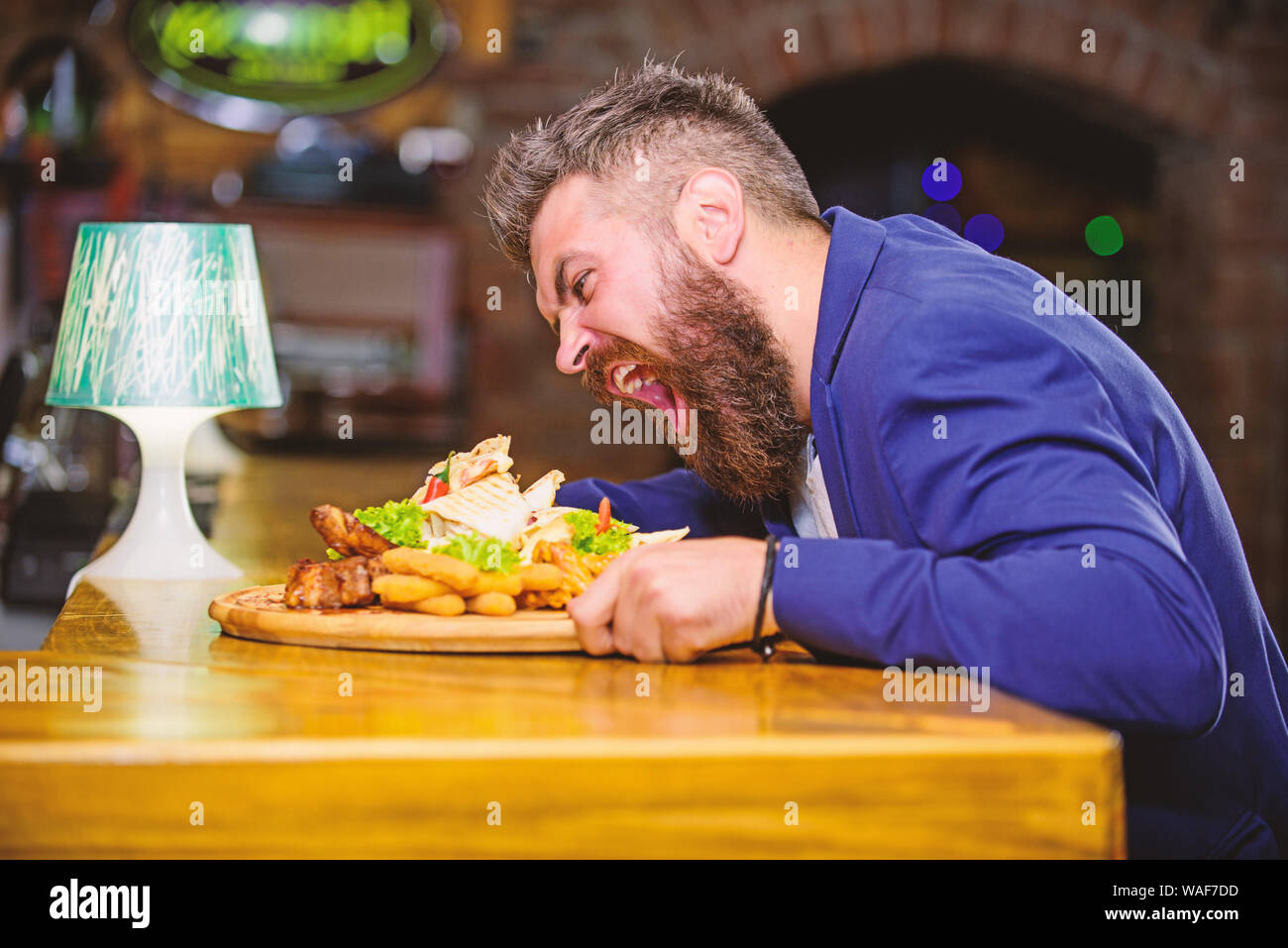 Profitez de repas. Tricher repas. Hipster faim manger pub aliments frits. Costume officiel Gestionnaire de siéger au comptoir du bar. Délicieux repas. L'homme a reçu de pommes de terre frites repas avec les bâtonnets de poisson viande. Des calories. Banque D'Images