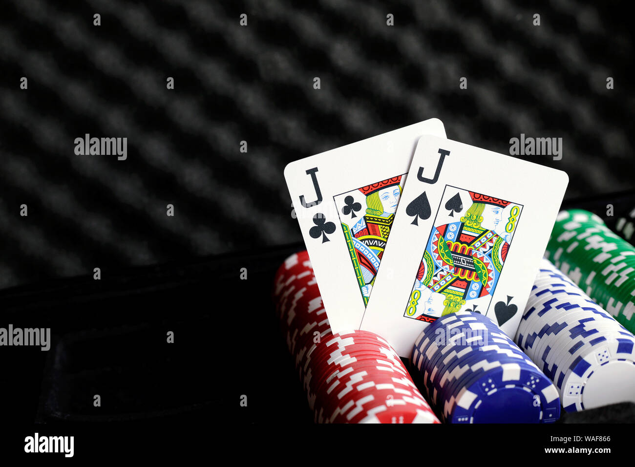 Paire de jacks jouant des cartes debout sur les jetons de poker Banque D'Images