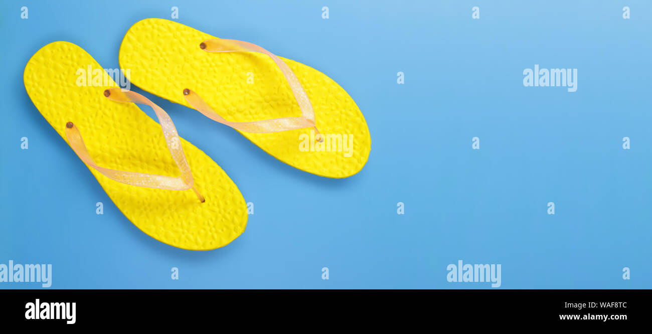 Vêtements, chaussures et accessoires - top view paire jaune tongs sandale sur un fond bleu Banque D'Images