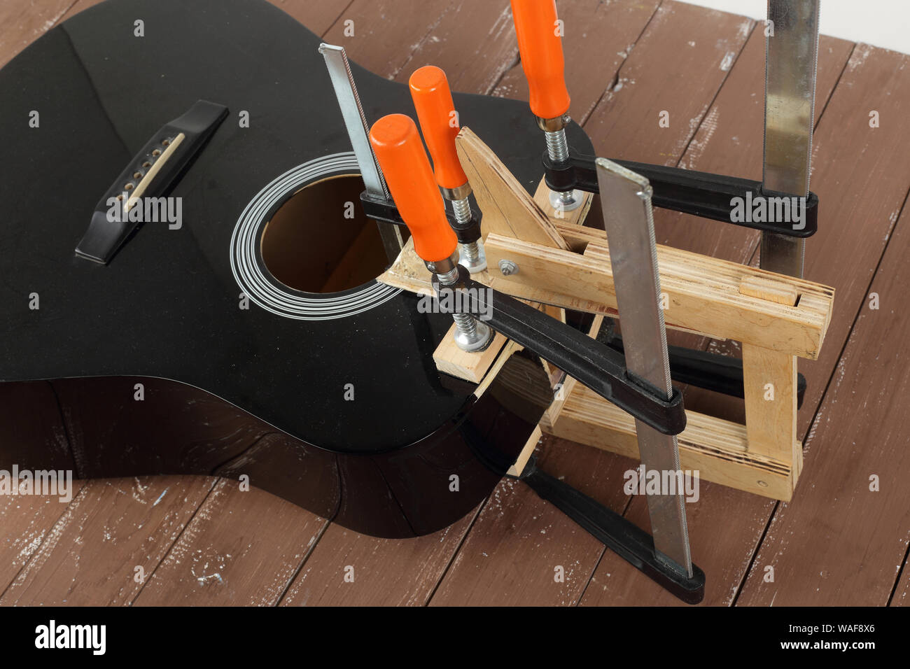 Service de réparation de guitares et de serrage - Réparation de la carte son de guitare acoustique cassé fond de bois Banque D'Images