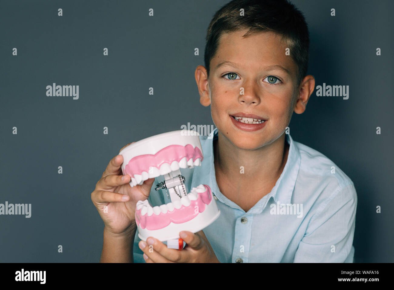 Cute boy modèle montrant des dents. Publicité drôle de traitement des dents de l'enfant Banque D'Images