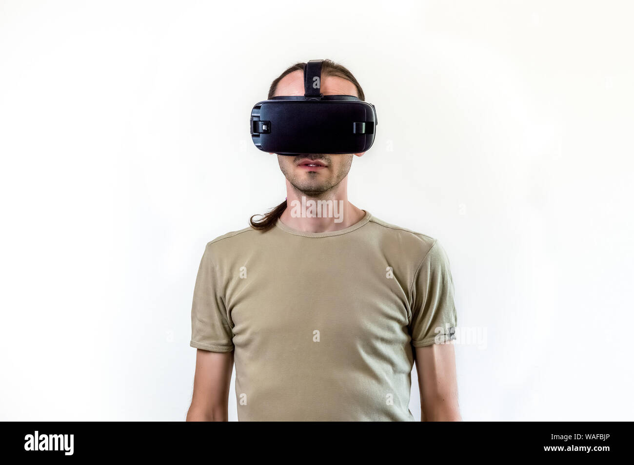 Caucasian man wearing shirt portant des lunettes de réalité virtuelle sur fond blanc. La future technologie concept. Banque D'Images