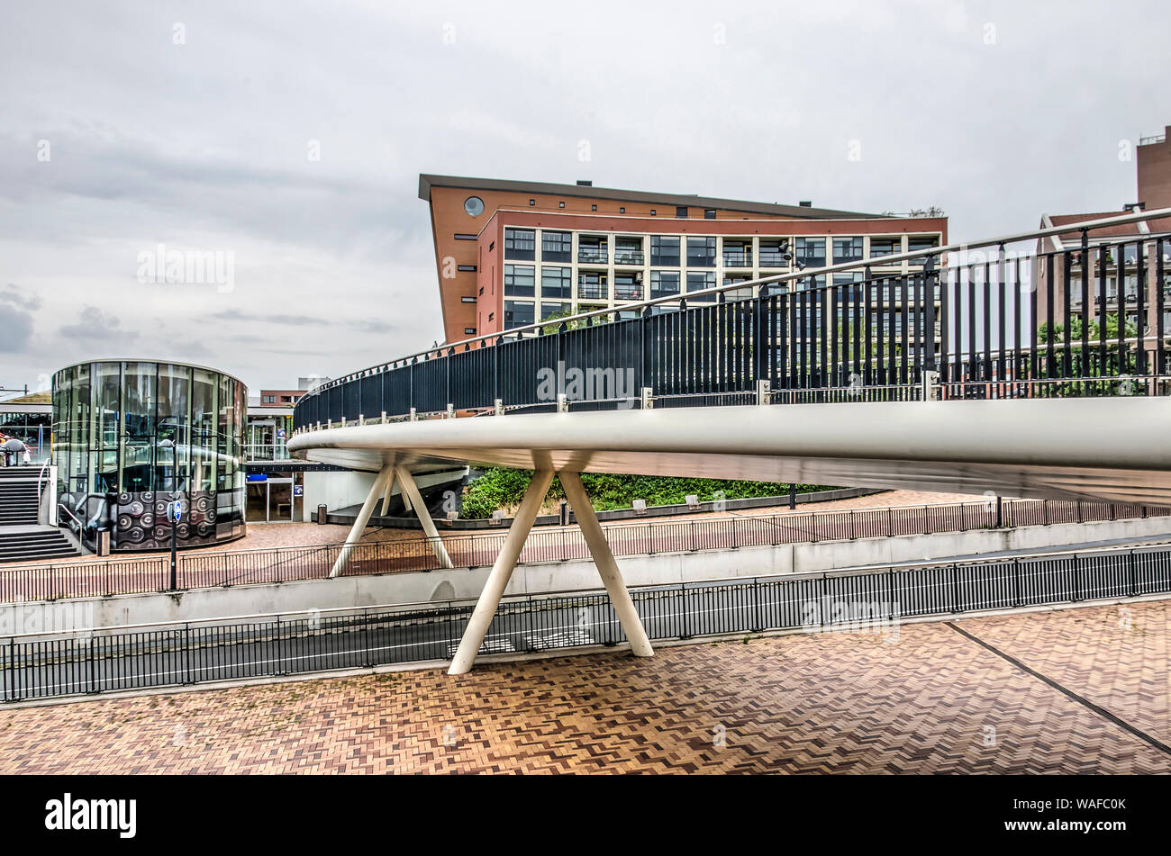 Helmond, Pays-Bas, 16 août 2019 : le côté ouest de la place de la gare avec un pont pour piétons et cyclistes de traverser la station animée St Banque D'Images