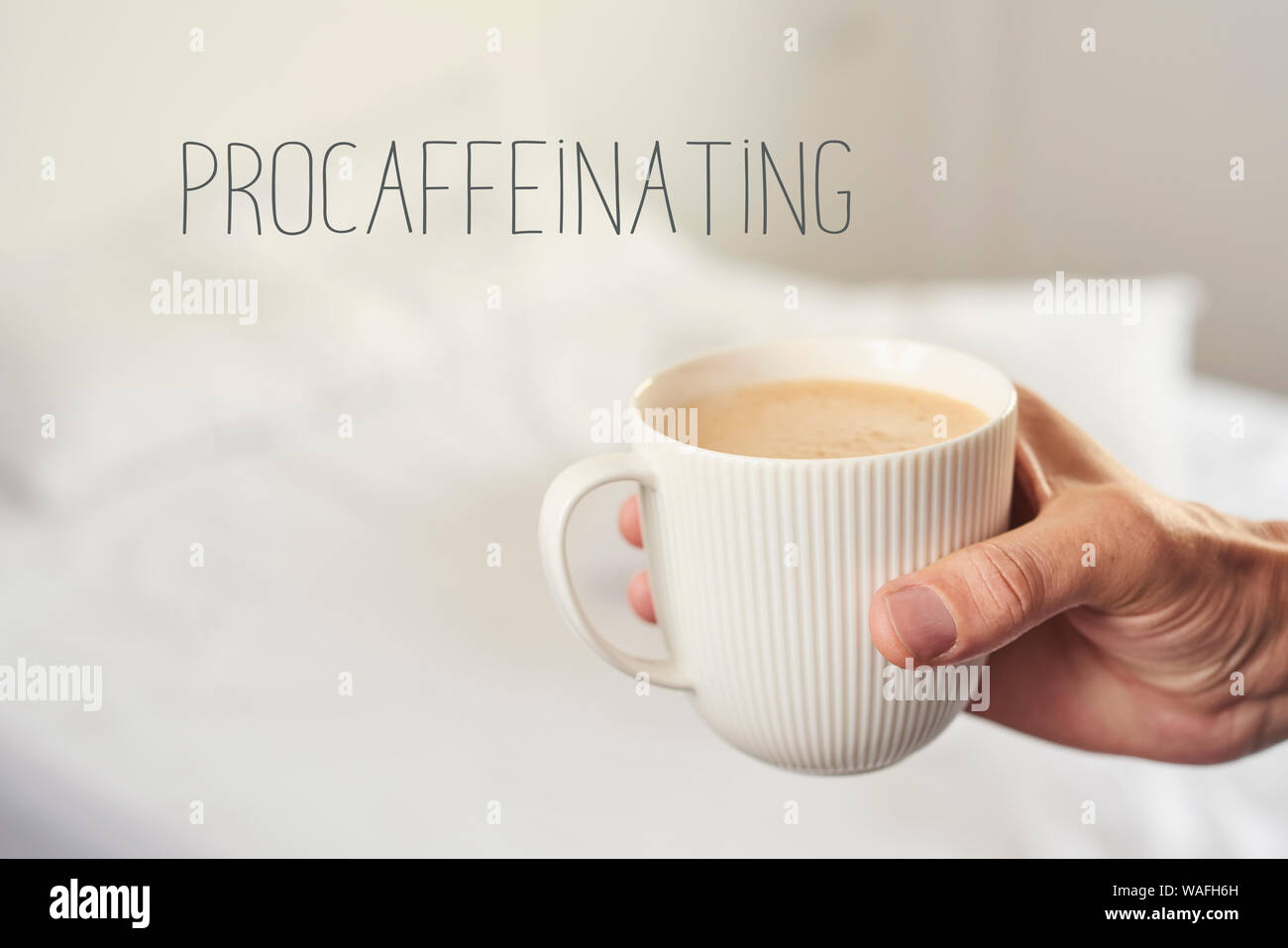 Libre d'un jeune homme de race blanche d'avoir un café dans une chambre, à côté du lit défait, et le texte procaffeinating, comme la tendance à ne pas démarrer anyt Banque D'Images