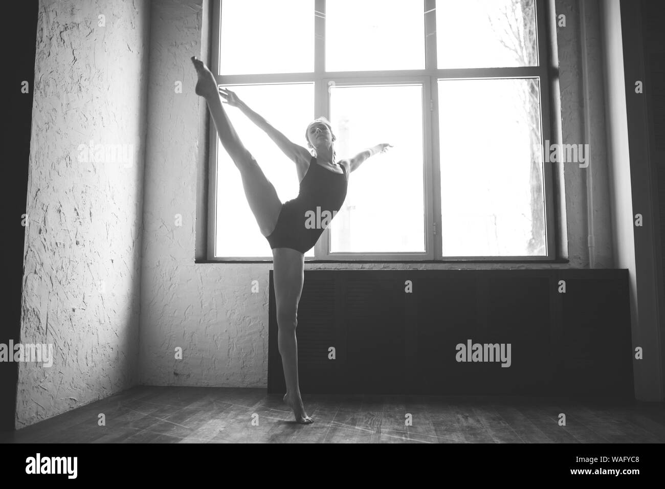 Plasticité femme mince dansant près de la fenêtre. Danseuse professionnelle danseuse. Lady Dancer Training Ballet moderne en classe. Danseur contemporain Banque D'Images