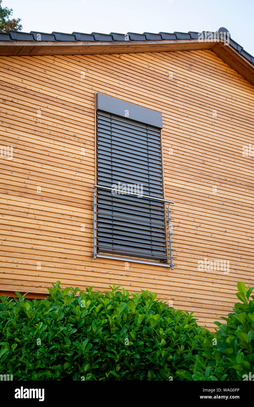 Fenêtre avec store fermé sur une chambre avec mur en bois Banque D'Images