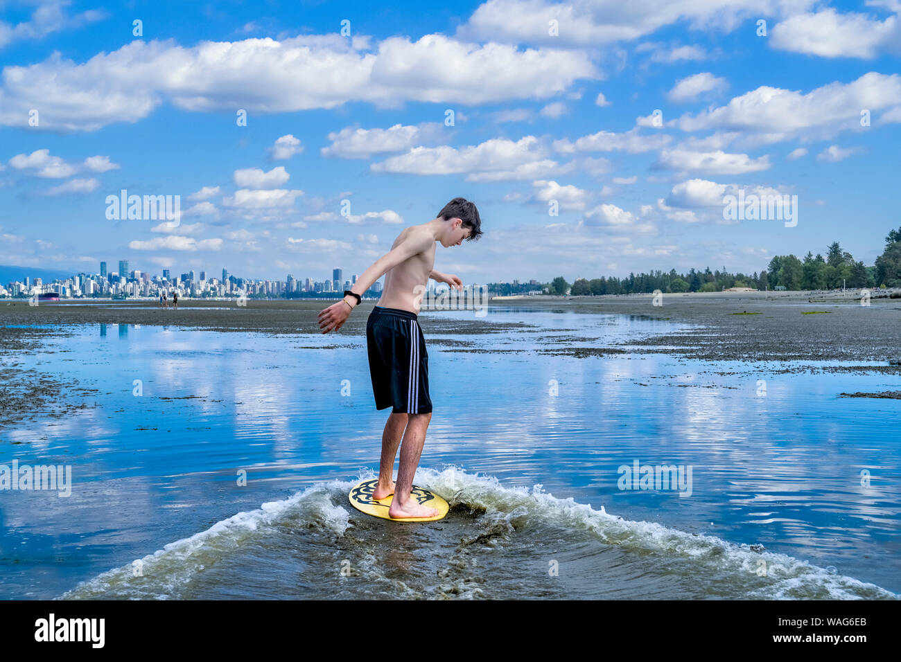 Adolescent, skimboarding banques espagnoles, English Bay, Vancouver, British Columbia, Canada Banque D'Images