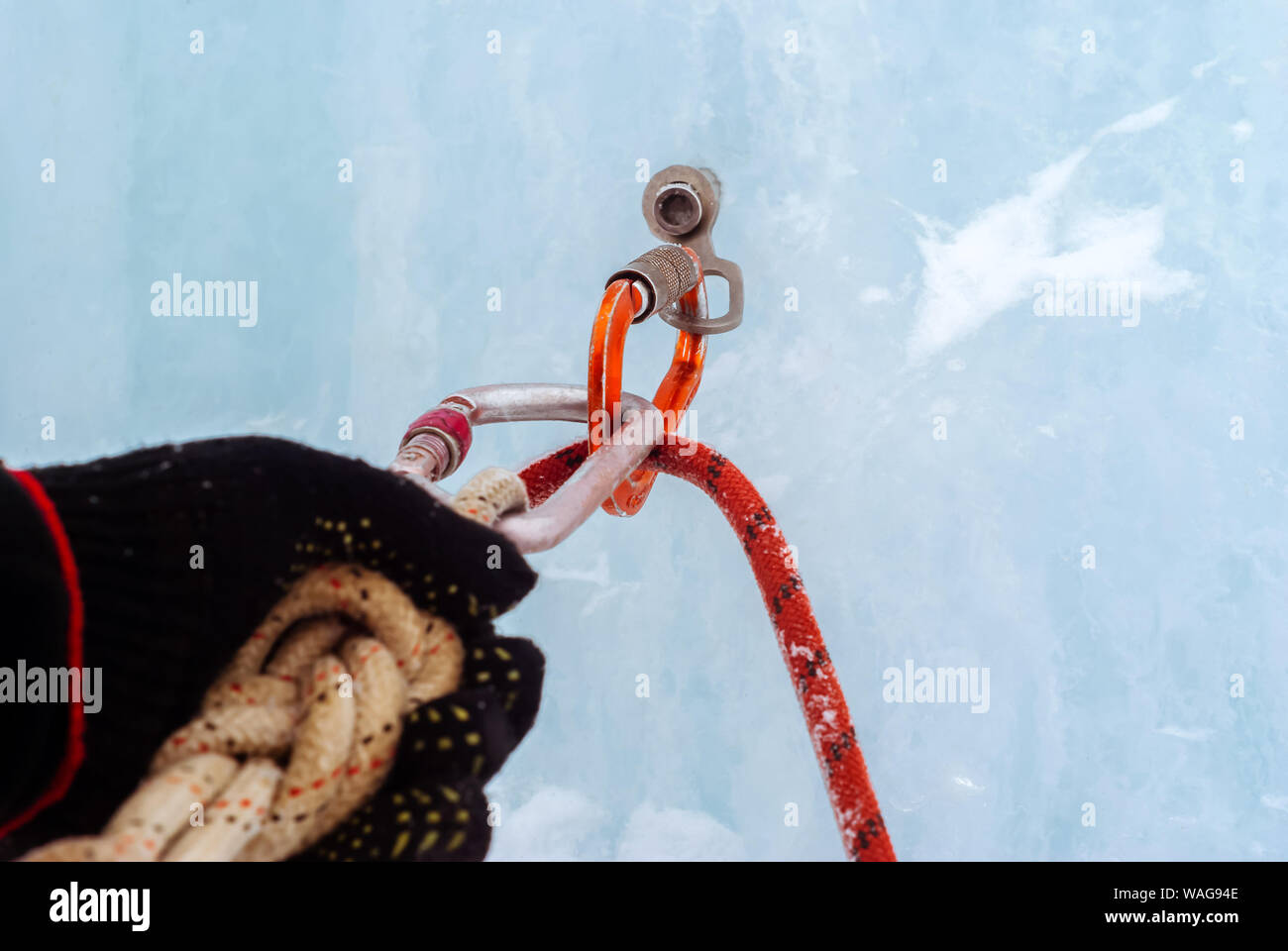 Cascade de glace d'ancrage avec broche à glace, corde de sécurité,  mousquetons et bras du grimpeur, gros plan Photo Stock - Alamy