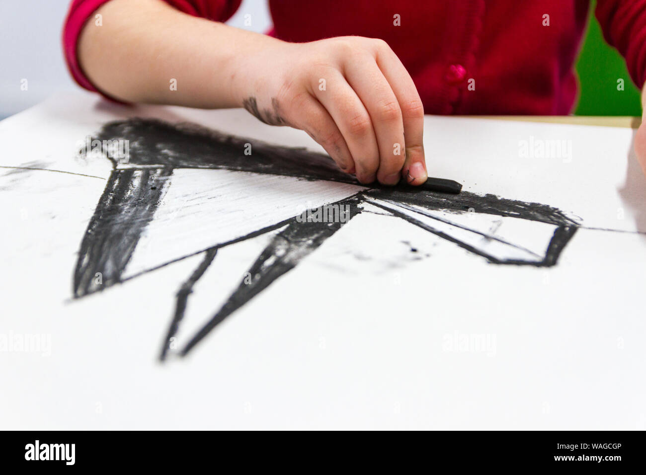 Dessin de l'enfant à l'école primaire avec un bâton de craie blanche, classe d'art, uk Banque D'Images