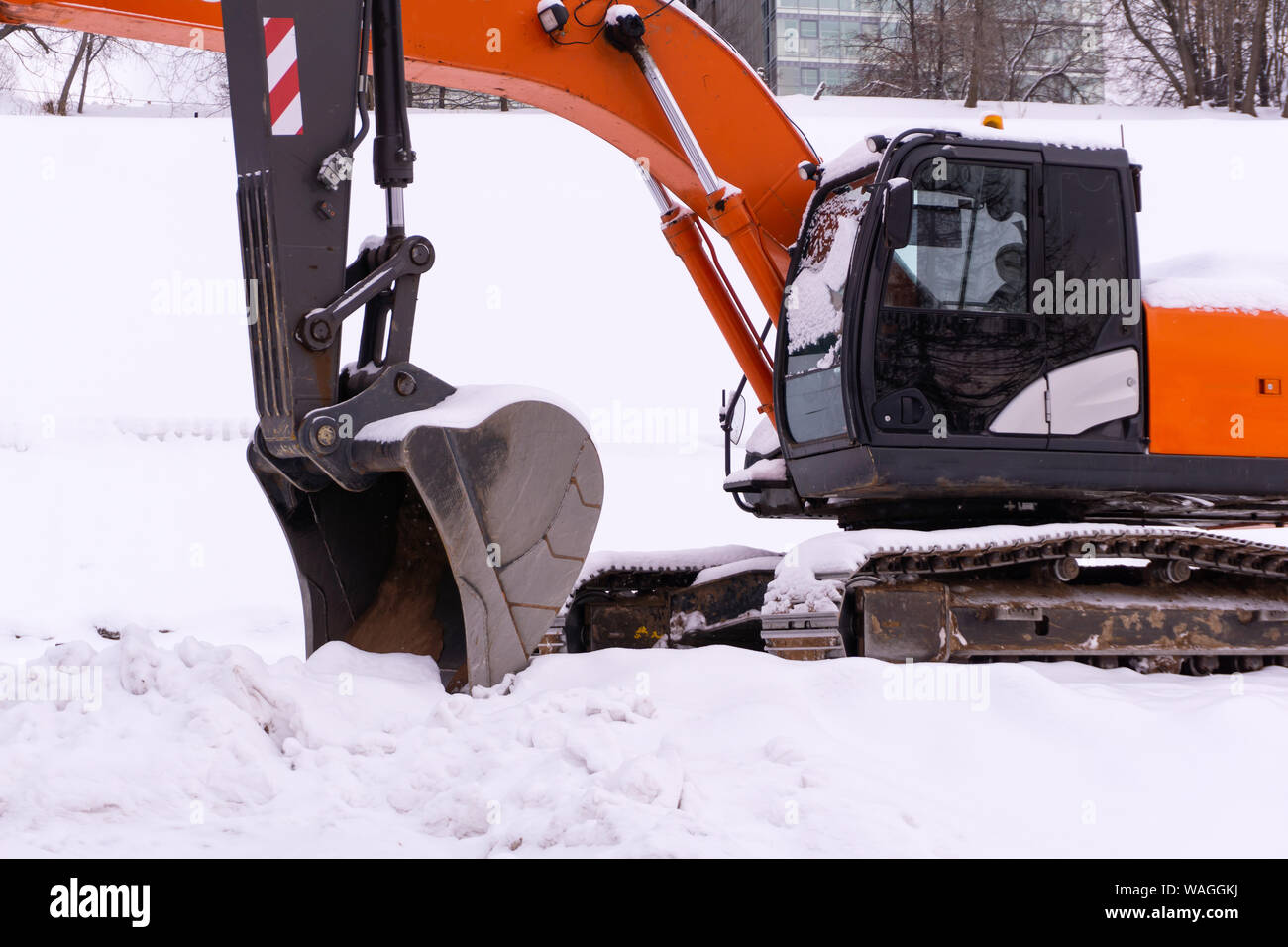 Deux excavatrices à chenilles lumineuses sont placées sur un champ neigeux, les rampes et les bâtons forment une enfilade Banque D'Images