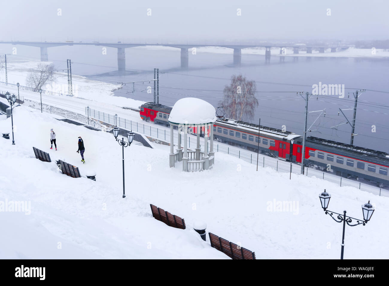 Paysage de neige d'hiver avec train électrique le long de la rivière avec une rotonde et pont vintage automobile dans l'arrière-plan, f Banque D'Images