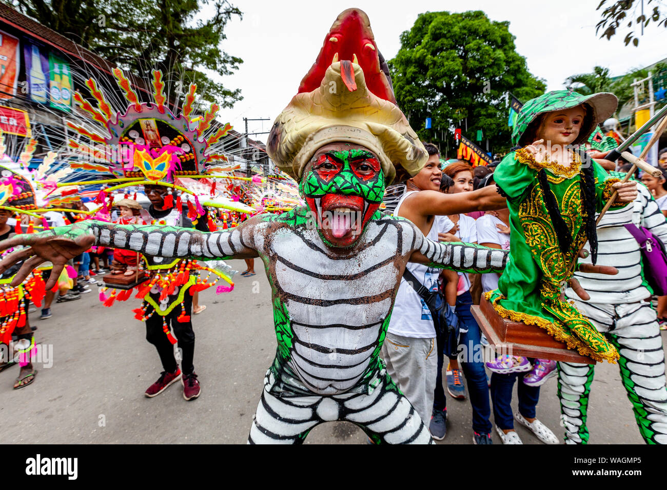 Les gens en costumes colorés Holding Santo Nino Statues parade dans les rues de Kalibo au cours de l'Ati-Atihan Festival, Kalibo, Philippines. Banque D'Images