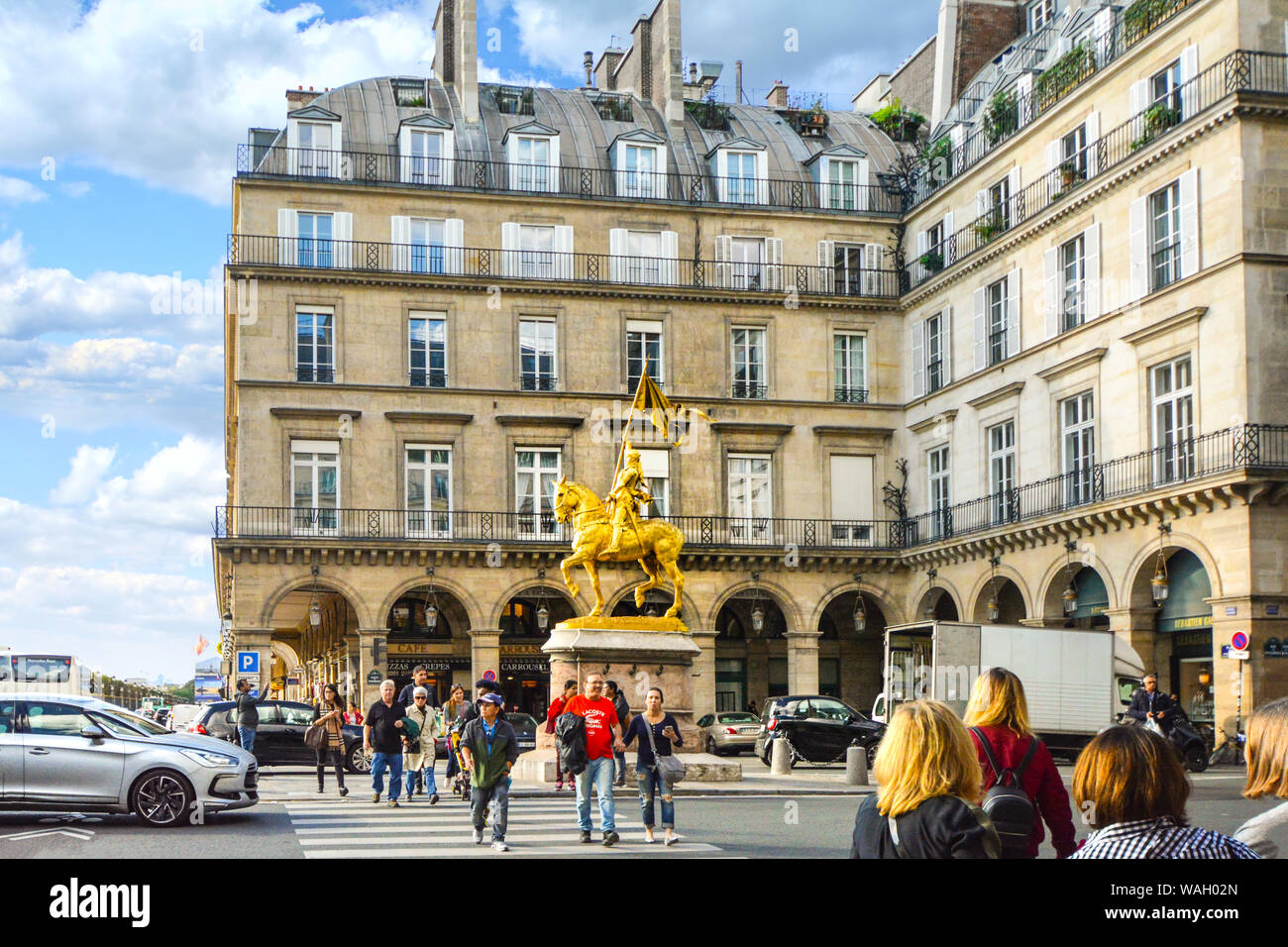 Un bronze doré sculpture équestre de Jeanne d'Arc par Emmanuel Frémiet dans la place des Pyramides à Paris France comme touristes à pied l'intersection Banque D'Images