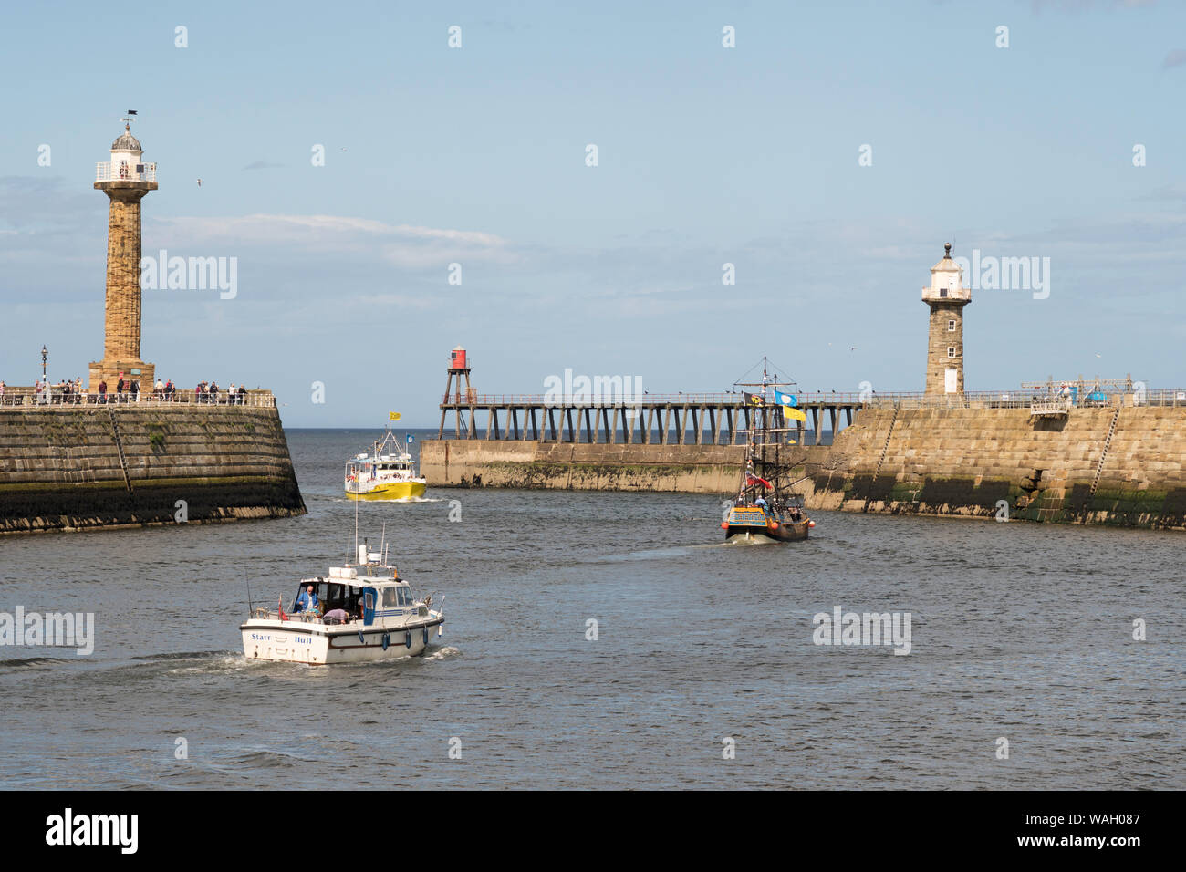 Les bateaux de plaisance et un bateau de pêche à l'entrée du port de Whitby, North Yorkshire, England, UK Banque D'Images