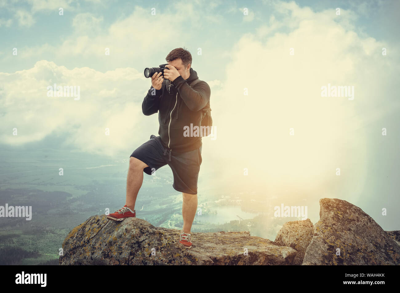 Un photographe sur le haut d'une falaise abrupte et skyline en haute montagne. Banque D'Images