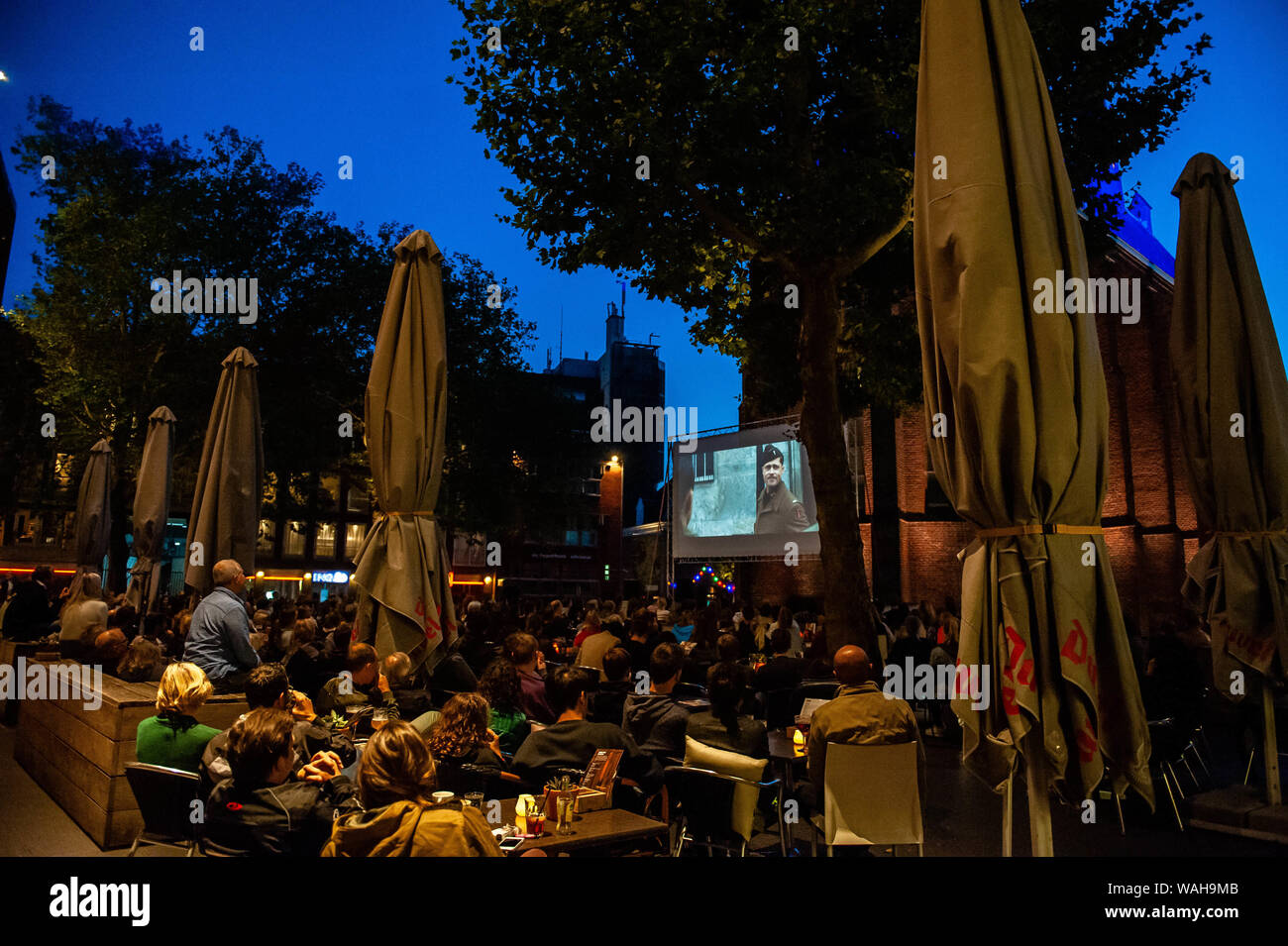 Nimègue, Gueldre, Pays-Bas. 20e Août, 2019. Les gens s'asseoir à l'extérieur tout en profitant d'un des films de Quentin Tarantino.Parce que le dernier film de Quentin Tarantino est sorti ce mois-ci, LUX une plate-forme libérale et indépendante à Nimègue pour de nouveaux développements dans l'art et de la culture a offert un cinéma de plein air projections de ses films bien connus, comme quatre chambres et Pulp Fiction. Des centaines de personnes pourraient profiter gratuitement les films, comme quatre chambres et Pulp Fiction dans un style très Tarantino. Credit : Ana Fernandez/SOPA Images/ZUMA/Alamy Fil Live News Banque D'Images