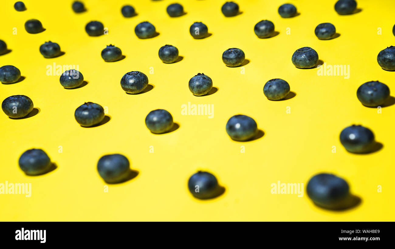 Modèle de bleuets frais sur fond jaune. Banque D'Images
