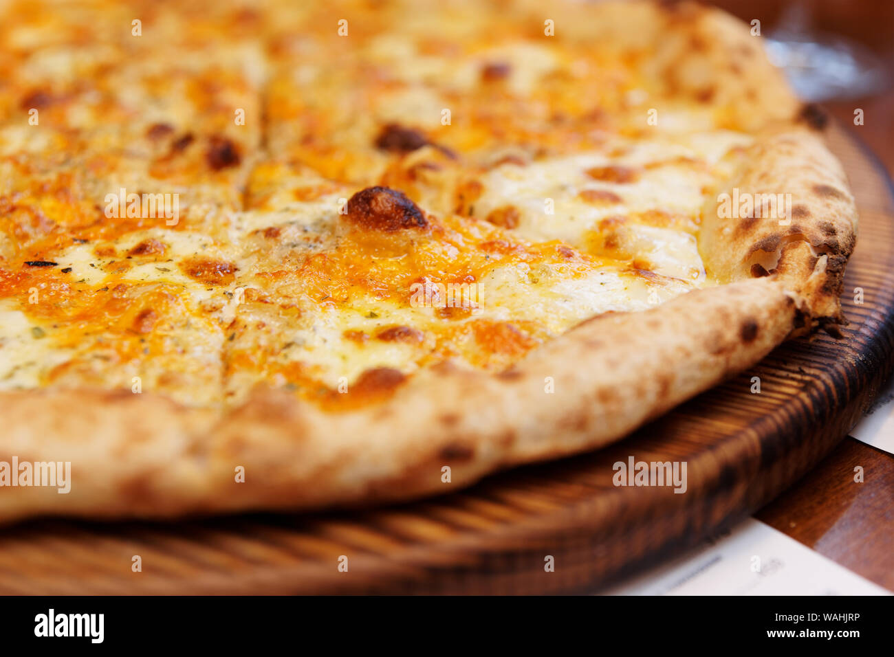 Quatre fromages pizza cuite au four à bois four frit, close-up sur le service à bord Banque D'Images