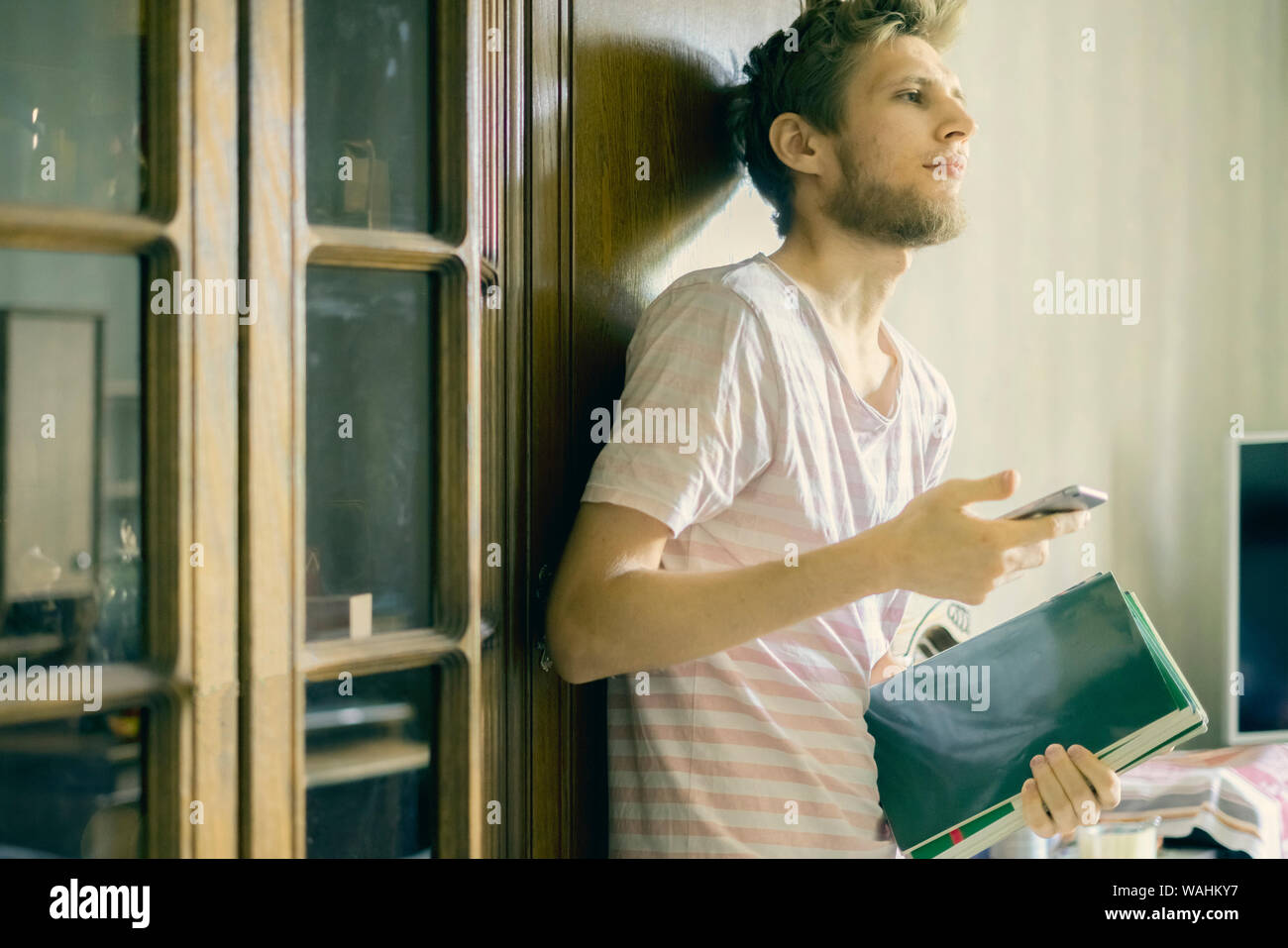 beau jeune barbu homme porte une petite pile de livres à l'université f Banque D'Images