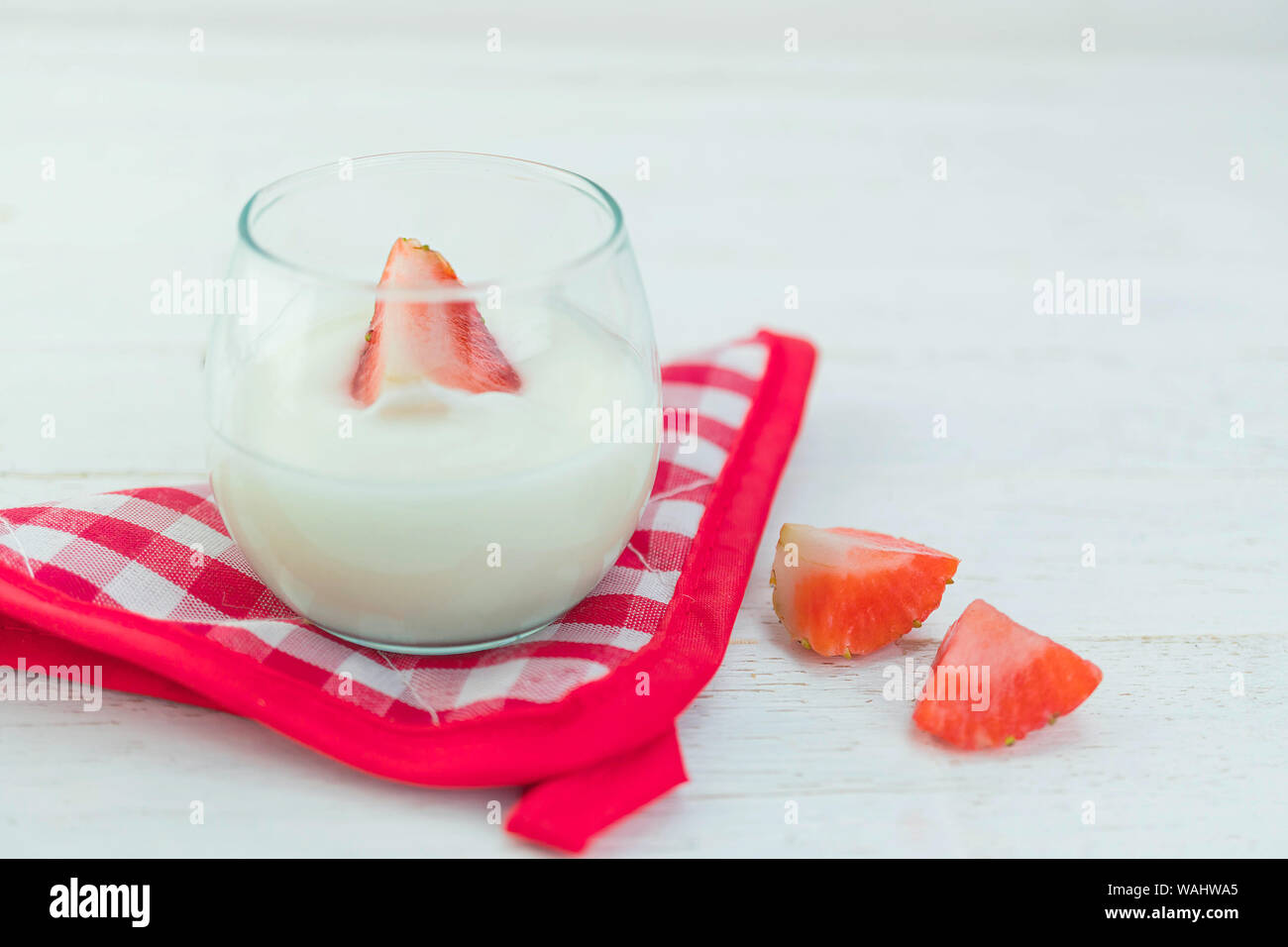 Saveur Original yaourt avec des fraises fraîches en verre clair sur fond de bois blanc Banque D'Images