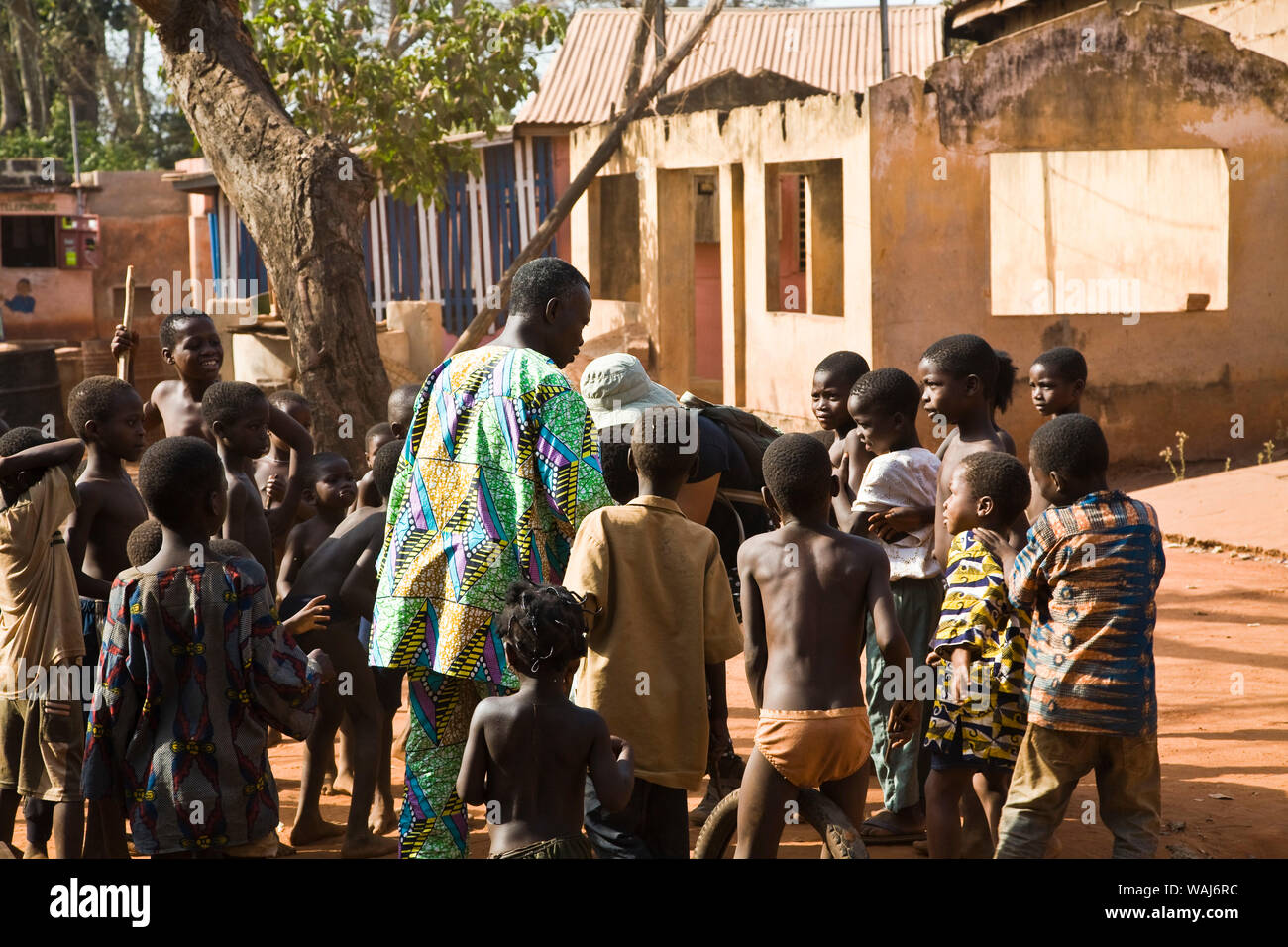 L'Afrique de l'ouest, au Bénin. Les enfants se sont réunis autour de l'homme danse des masques Gelede avant. Banque D'Images