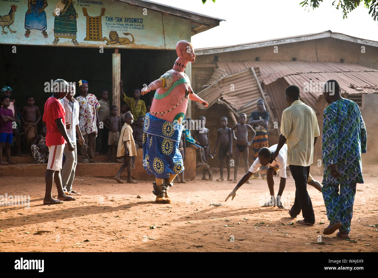 L'Afrique de l'ouest, au Bénin. Les hommes et les enfants regarder les spectacles de danse de masque Gelede. Banque D'Images
