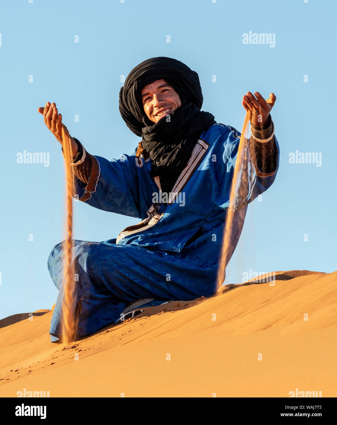 L'Afrique, le Maroc, l'Erg Chebbi. Homme Touareg nomades sur dune jouer avec du sable. En tant que crédit : Bill Young / Jaynes Gallery / DanitaDelimont.com (usage éditorial uniquement) Banque D'Images