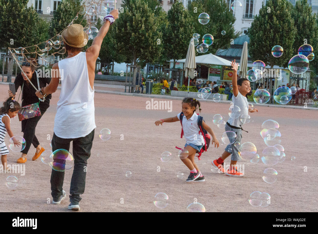 Les enfants qui jouent avec des bulles de savon. La Place Bellecour. Lyon, France. Banque D'Images