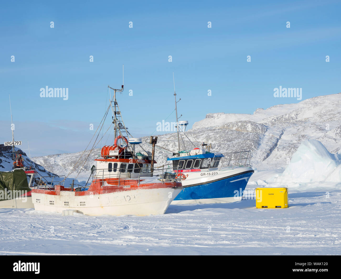 Ikerasak village de pêche en hiver, dans l'Uummannaq Fjord, au nord du cercle polaire. Bateaux de pêche dans le port gelé. Le Groenland. Banque D'Images