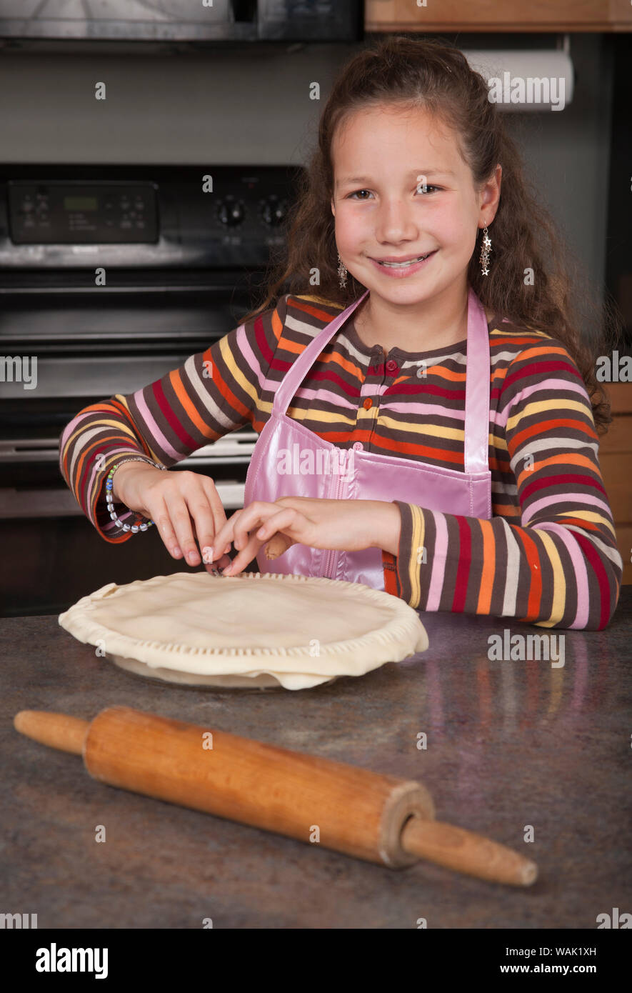 Sertissage de fille les bords de sa tarte aux pommes faite maison. (MR, communication) Banque D'Images