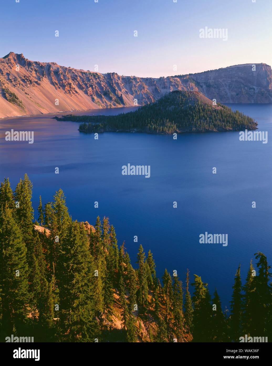 USA, Ohio, Crater Lake National Park. Lever du soleil sur la rive ouest du lac de cratère avec pointe Hillman (à gauche) et Llao Rock (à droite) donnant sur l'île de l'Assistant. Banque D'Images