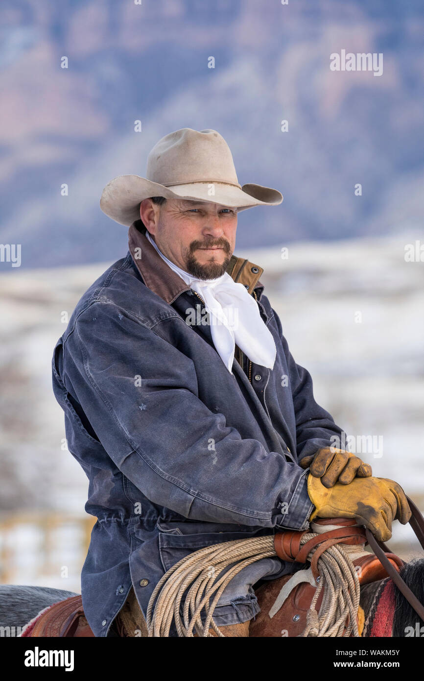 Cheval de cow-boy dur sur Hideout Ranch, Shell, Wyoming. Cowboy assis dans la selle. (MR) Banque D'Images