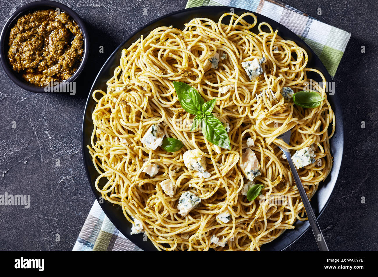 Close-up of spaghetti au pesto de basilic genovese et le fromage bleu sur une plaque noire sur une table, une vue de dessus, flatlay, copy space Banque D'Images