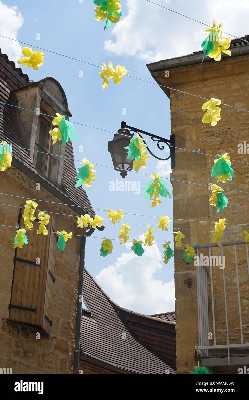 Gros plan sur une scène de village français avec des décorations de fête de fleurs suspendues Banque D'Images