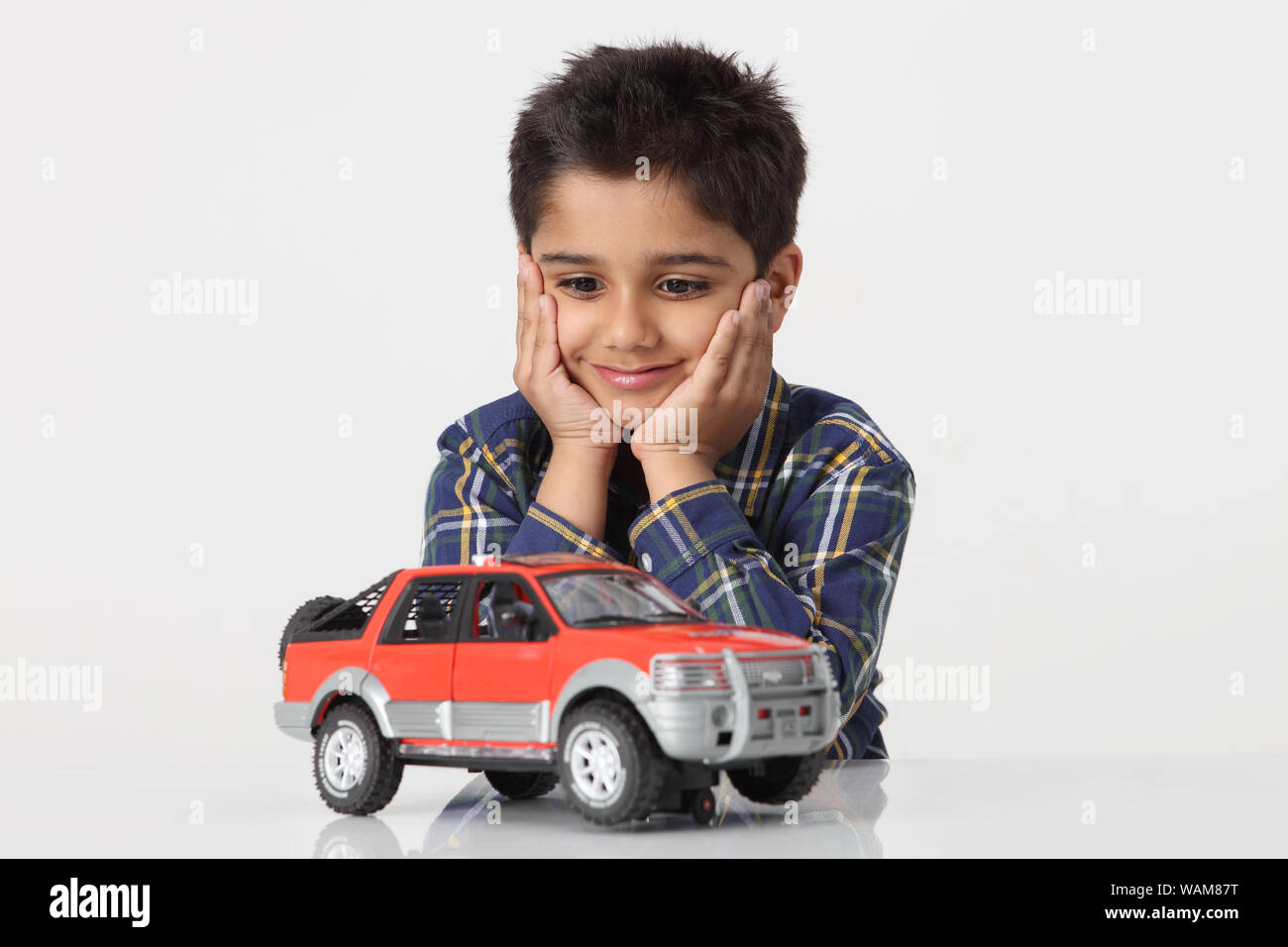 Garçon à la recherche de sa voiture-jouet Photo Stock - Alamy