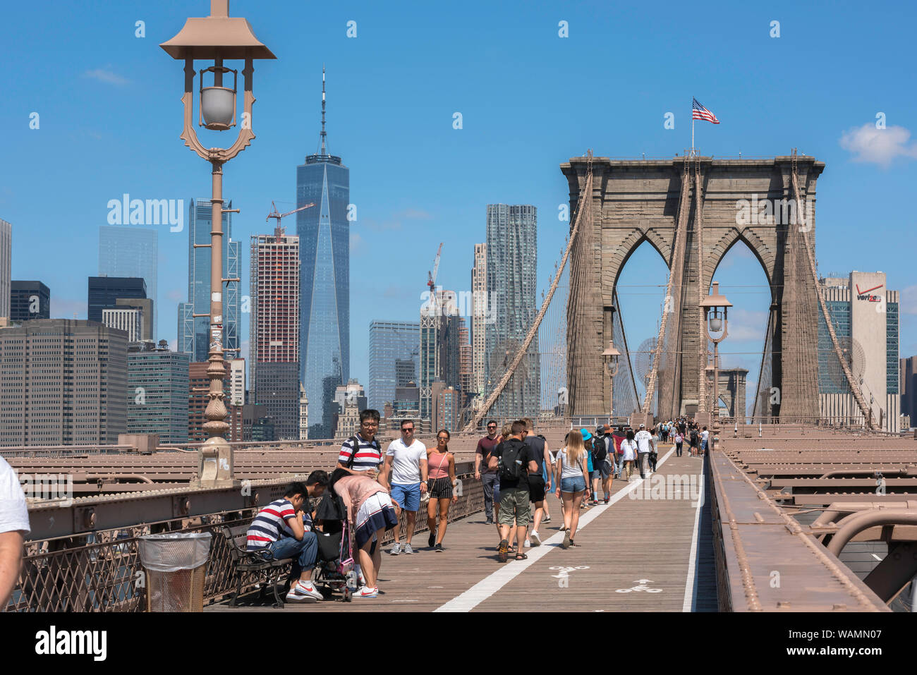 Pont de Brooklyn, vue sur les gens qui marchent à travers le pont de Brooklyn en été avec la ligne d'horizon de Lower Manhattan en arrière-plan, New York City, États-Unis Banque D'Images