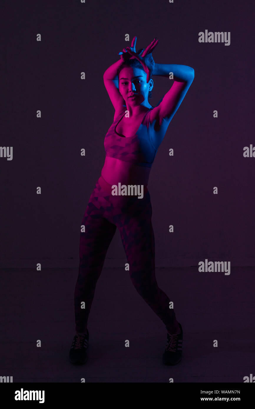 Portrait d'une jeune danseuse dans une couleur vive lumière dans le studio Banque D'Images