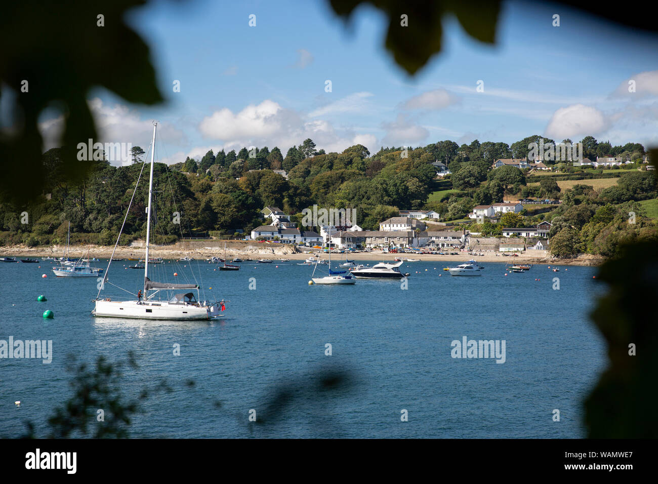 Un petit passage Helford cornish village sur la rivière Helford, vue à travers les arbres de la région de Cornwall, Angleterre Helford Banque D'Images