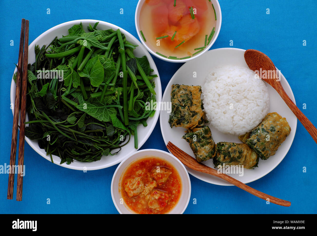Vue de dessus le déjeuner repas Vietnamien avec des légumes bouillis, tofu fromage, soupe de tomate, œuf frit avec de l'armoise, de nourriture vegan pour les végétariens sur bleu Banque D'Images