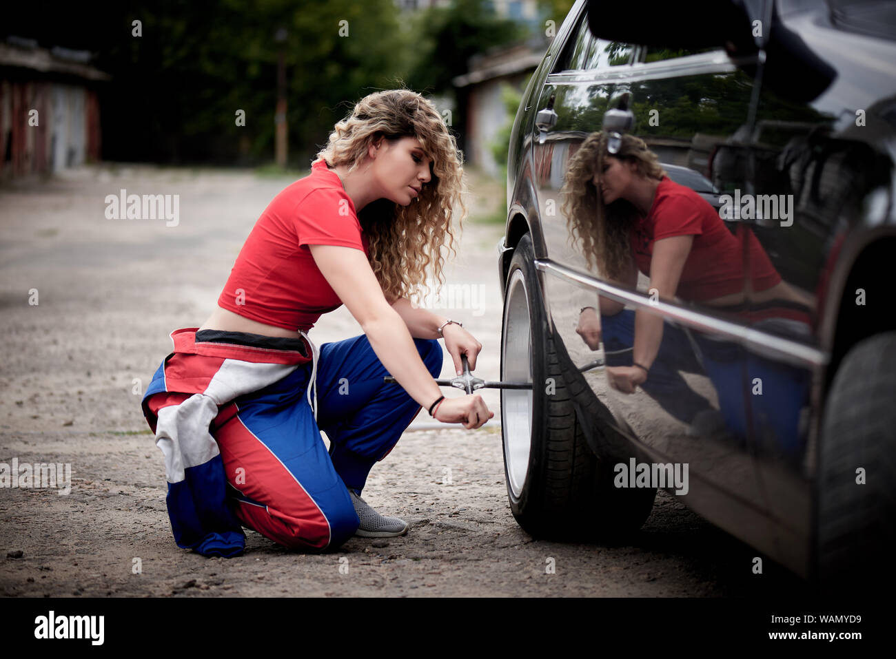 Une jeune femme en salopette sur un garage est la réparation d'une auto  Photo Stock - Alamy