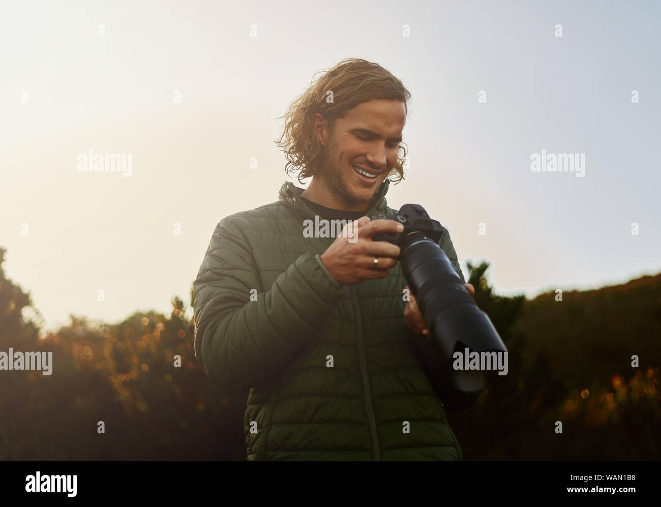 Photographe de la faune smiling après vérification sur l'appareil-photos Banque D'Images