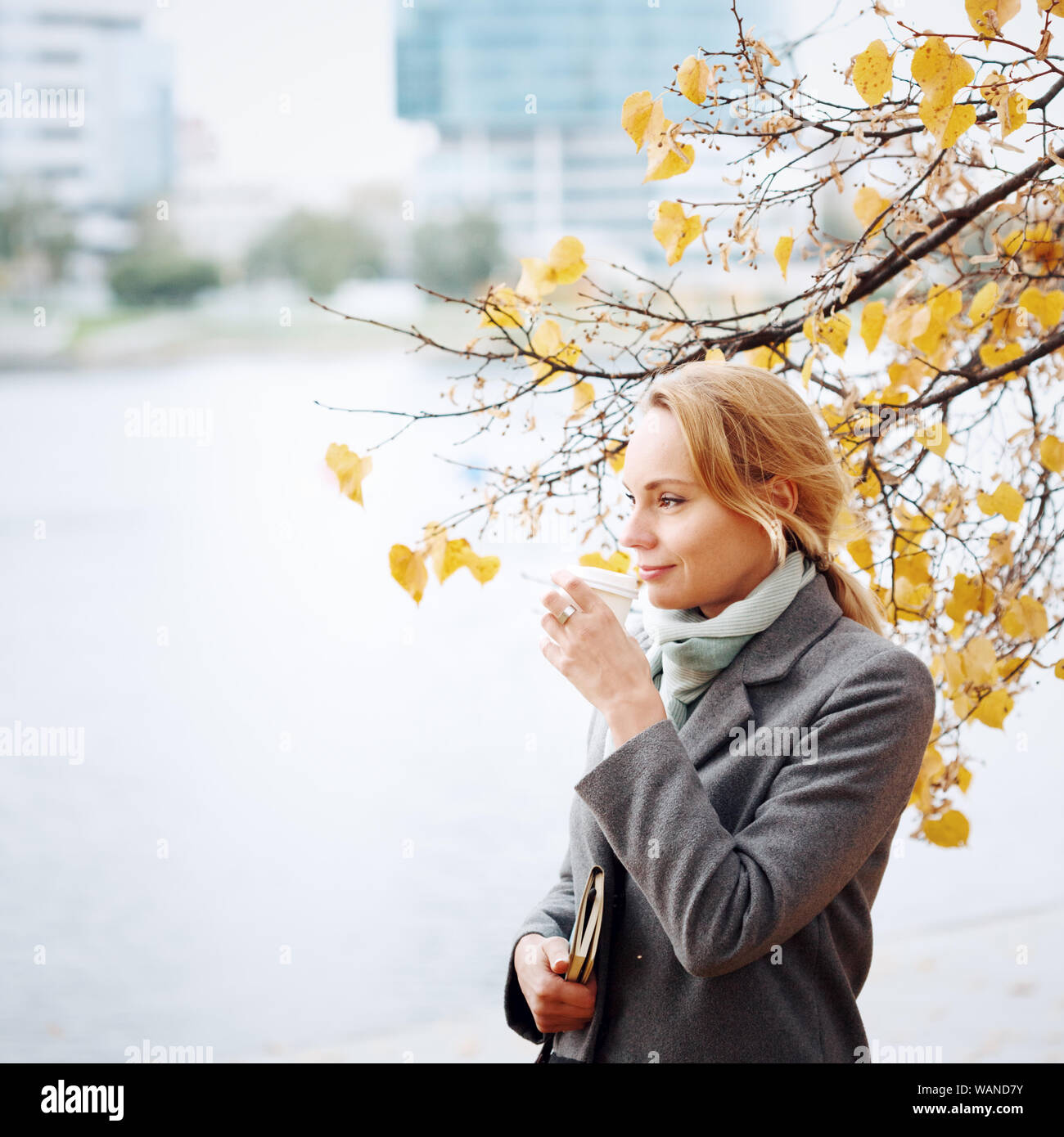 Young woman walking et de boire du café à emporter dans la ville, saison d'automne, copy space Banque D'Images