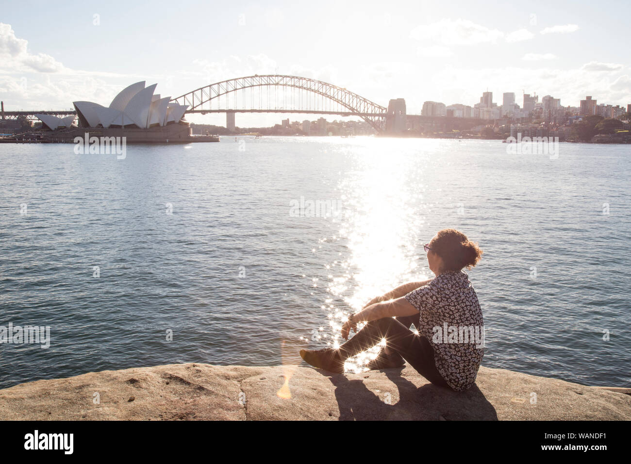 Jeune homme aux cheveux bouclés, au port de Sydney, pendant la golden sunset Banque D'Images