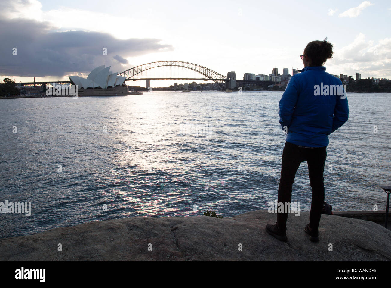 Un homme pendant le coucher du soleil, la fixant à l'Opéra de Sydney Banque D'Images