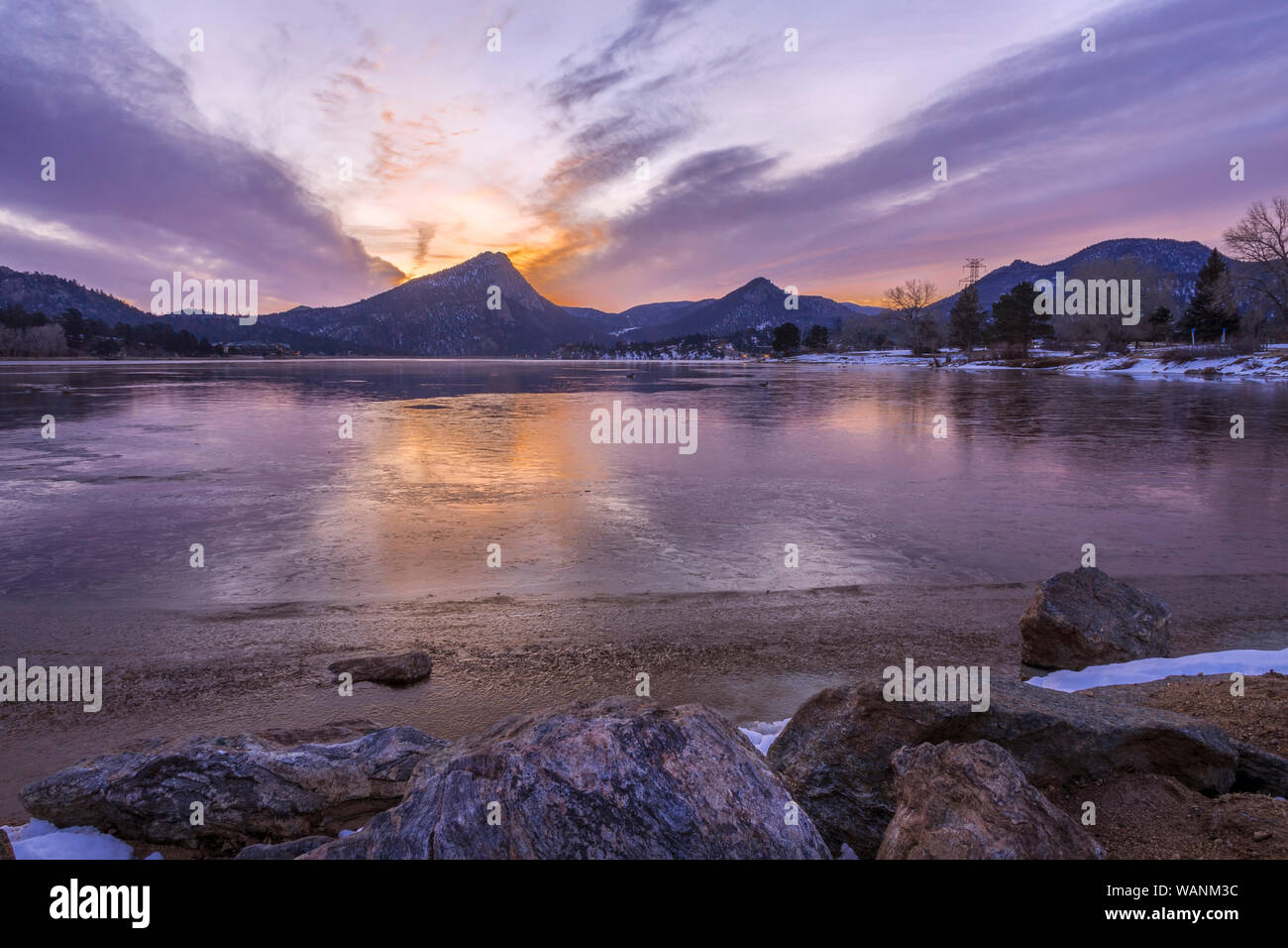 Le soleil commence à illuminer le ciel au-dessus de l'Olympe comme les nuages sortent de l'emblématique montagne à l'est du lac estes dans Estes Park, couleur Banque D'Images