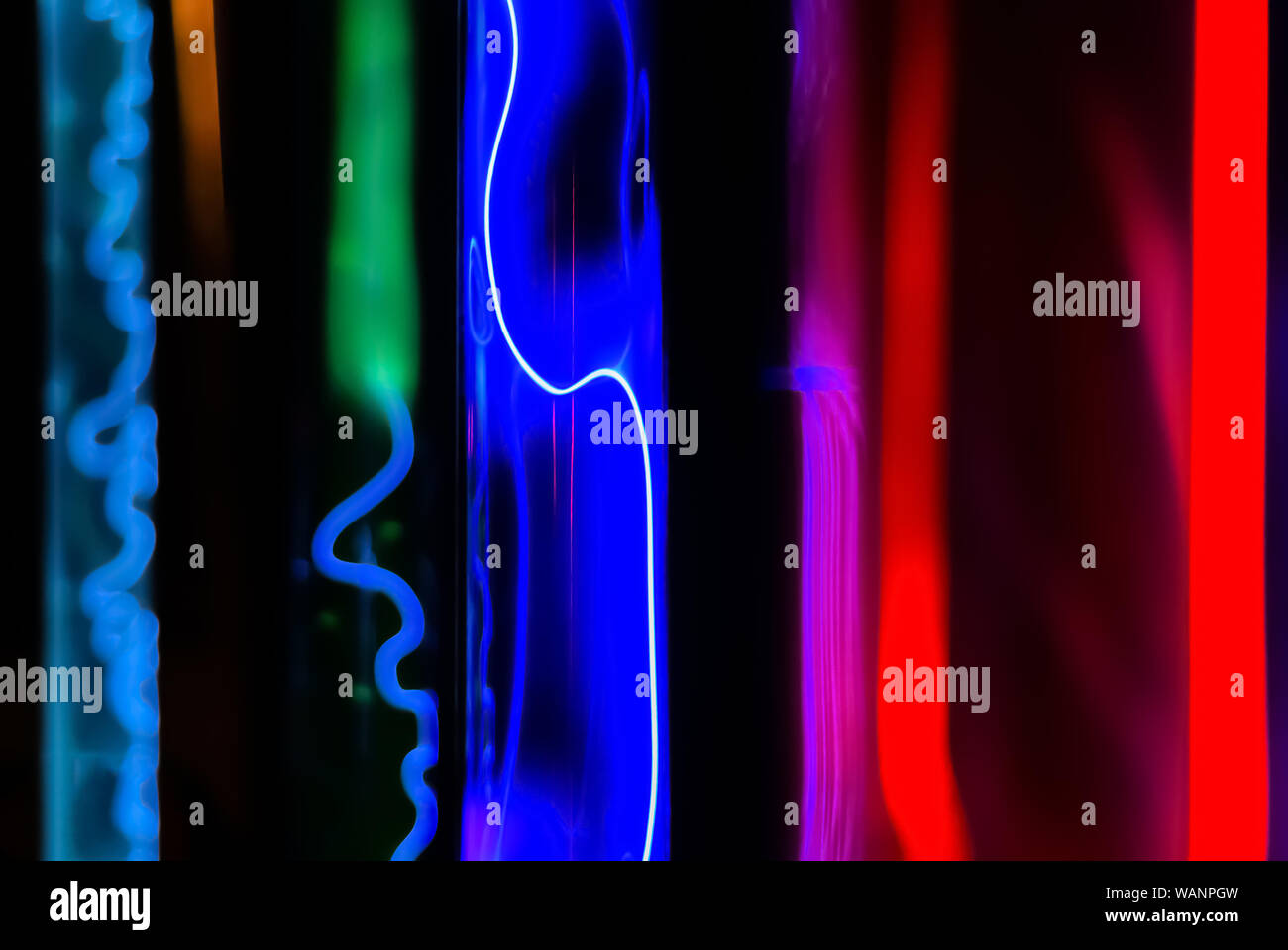 Résumé fond fluorescent - glow multicolore de divers gaz inertes dans des tubes de plasma sous l'action d'une décharge électrique Banque D'Images